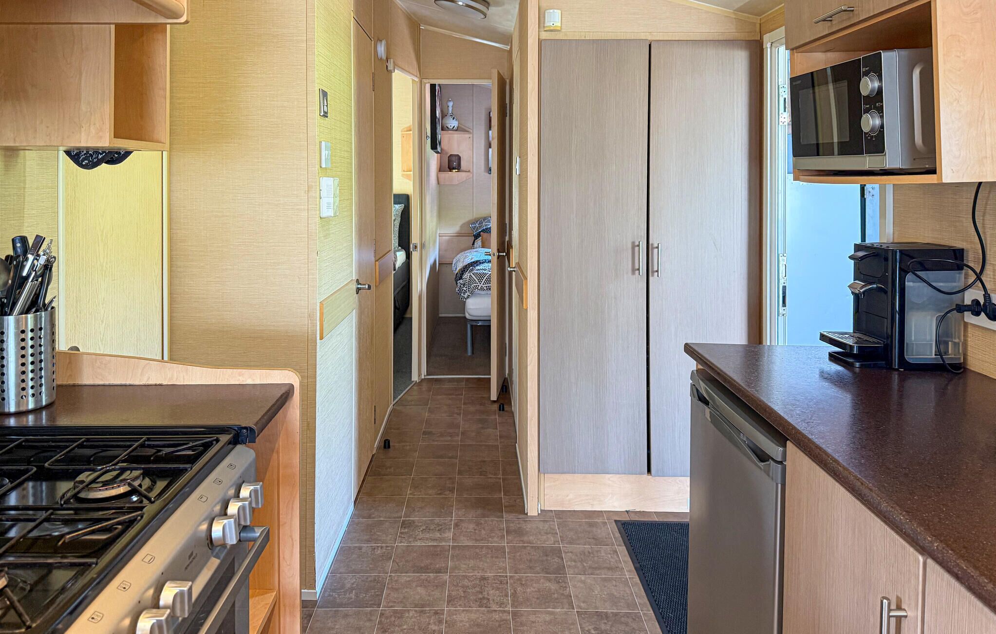 A compact kitchen with a stove, microwave, and dishwasher.