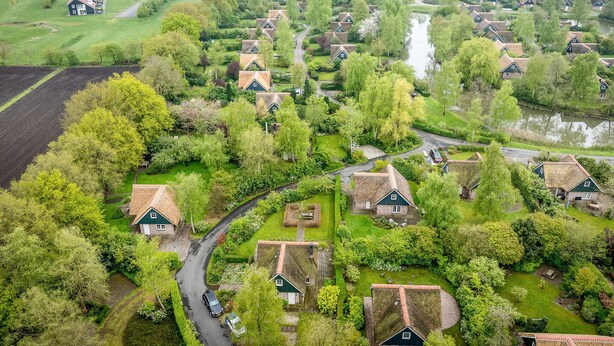 Oversigtsbillede fra luften af en landlig landsby med traditionelle huse, smalle veje og grønne omgivelser.
