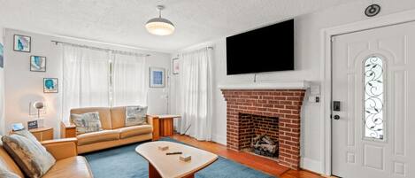 TV connectée, cheminée, livres, vidéothÚque