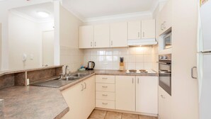 A modern kitchen with a granite countertop, stainless steel sink, and a built-in oven.