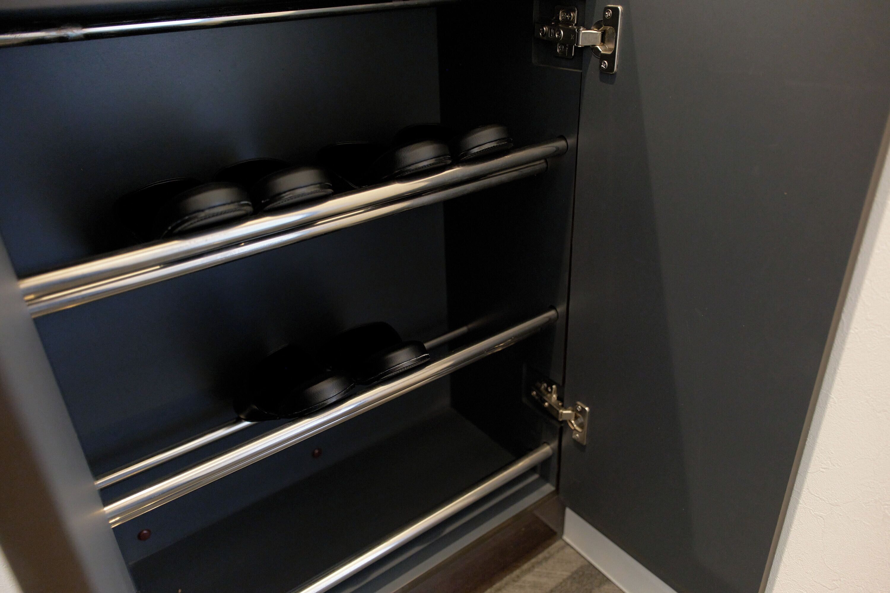 Ein dunkel gefärbter Schrank mit drei Einlegeböden, einem Metallgriff und einem Riegel.