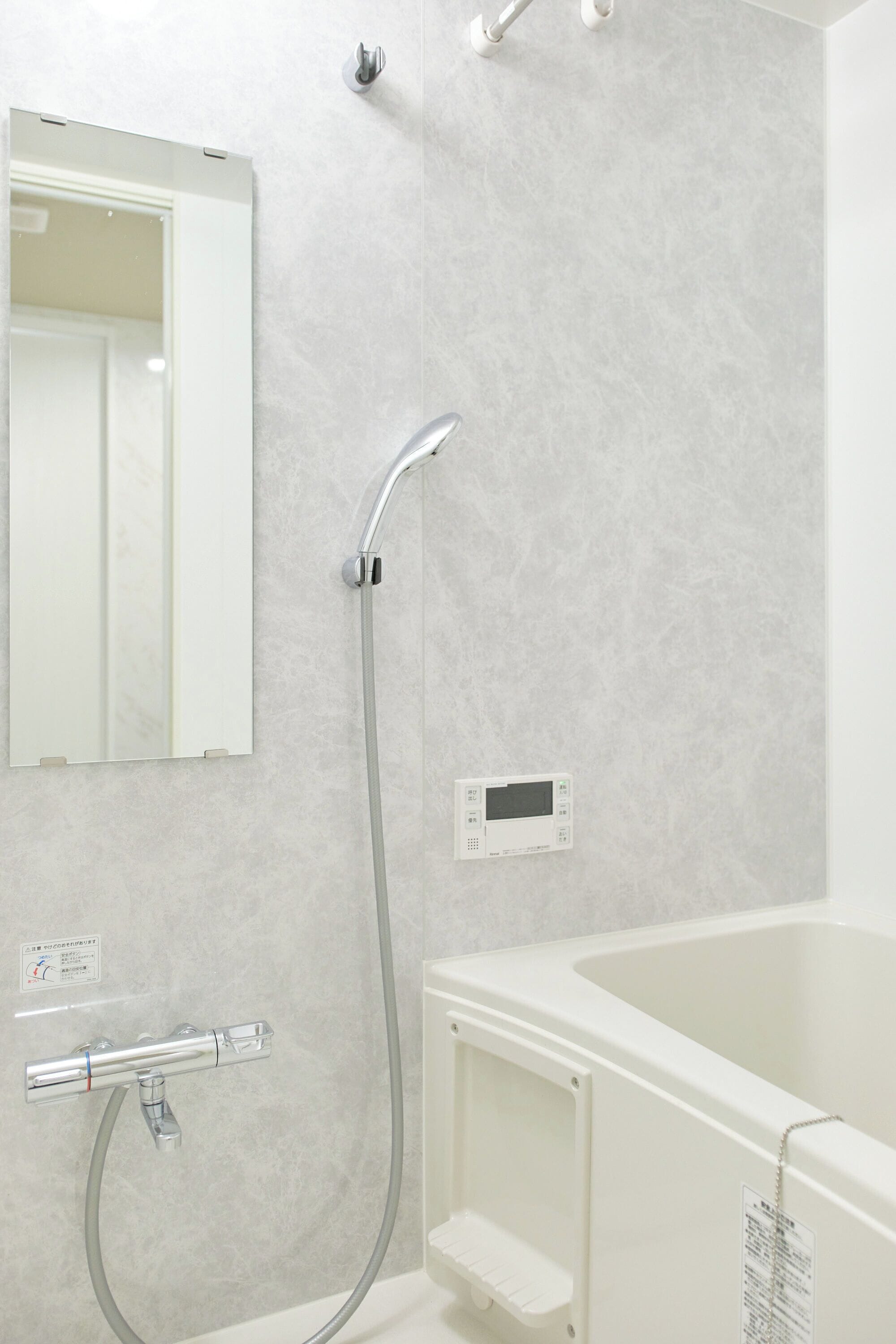 A bathroom with a shower, a toilet, a sink, and a mirror.