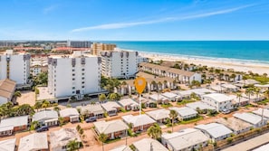 A coastal residential area with beachfront properties, including multi-story buildings and single-family homes.