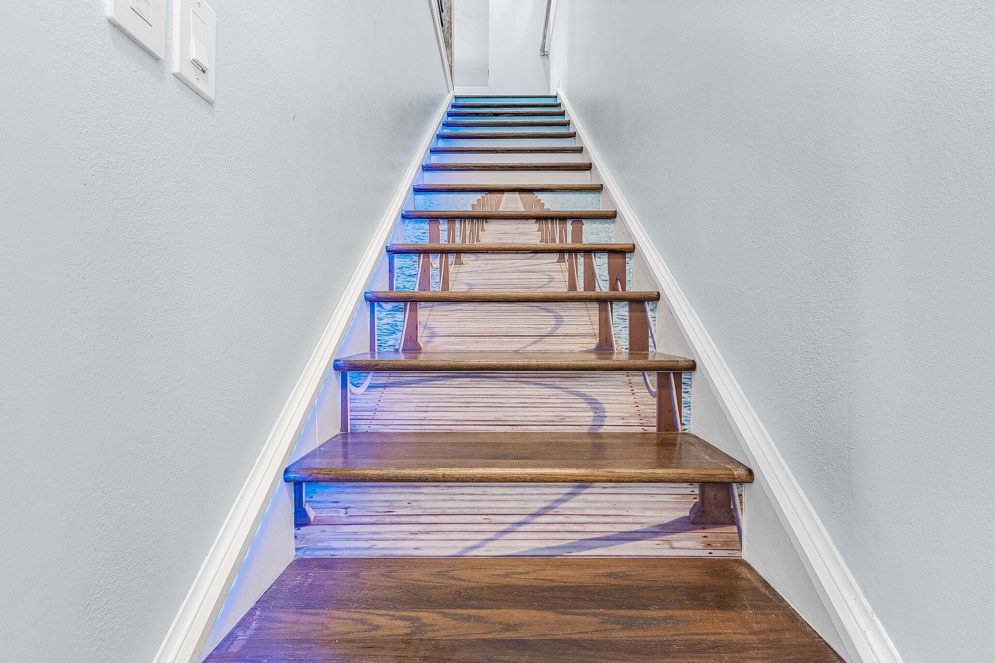 A wooden staircase with a handrail, leading to an upper floor.
