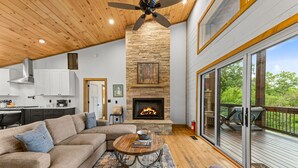 Amplia sala de estar con chimenea, un sofá grande y un comedor.