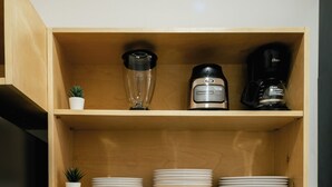 A kitchen with a granite countertop, a stainless steel sink, a coffee maker, and a blender on a wooden shelf. - Apartment next to the Malecon of La Paz BCS "DON MANOLO". (La Paz)