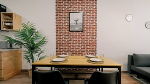 Un comedor con pared de ladrillo, un cuadro enmarcado y una planta.