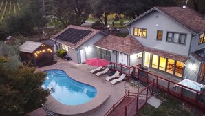 A residential backyard with a swimming pool, lounge chairs, a red umbrella, and a house with solar panels. - New Listing! Water & Vine In Sebastopol (Sebastopol)