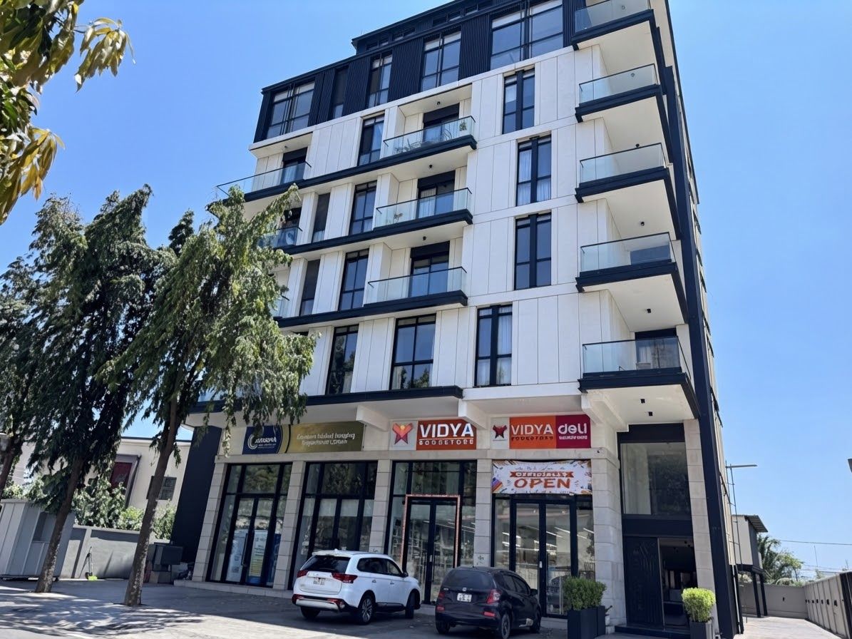 A multi-story building with commercial spaces on the ground floor, including a store named VIDYA.