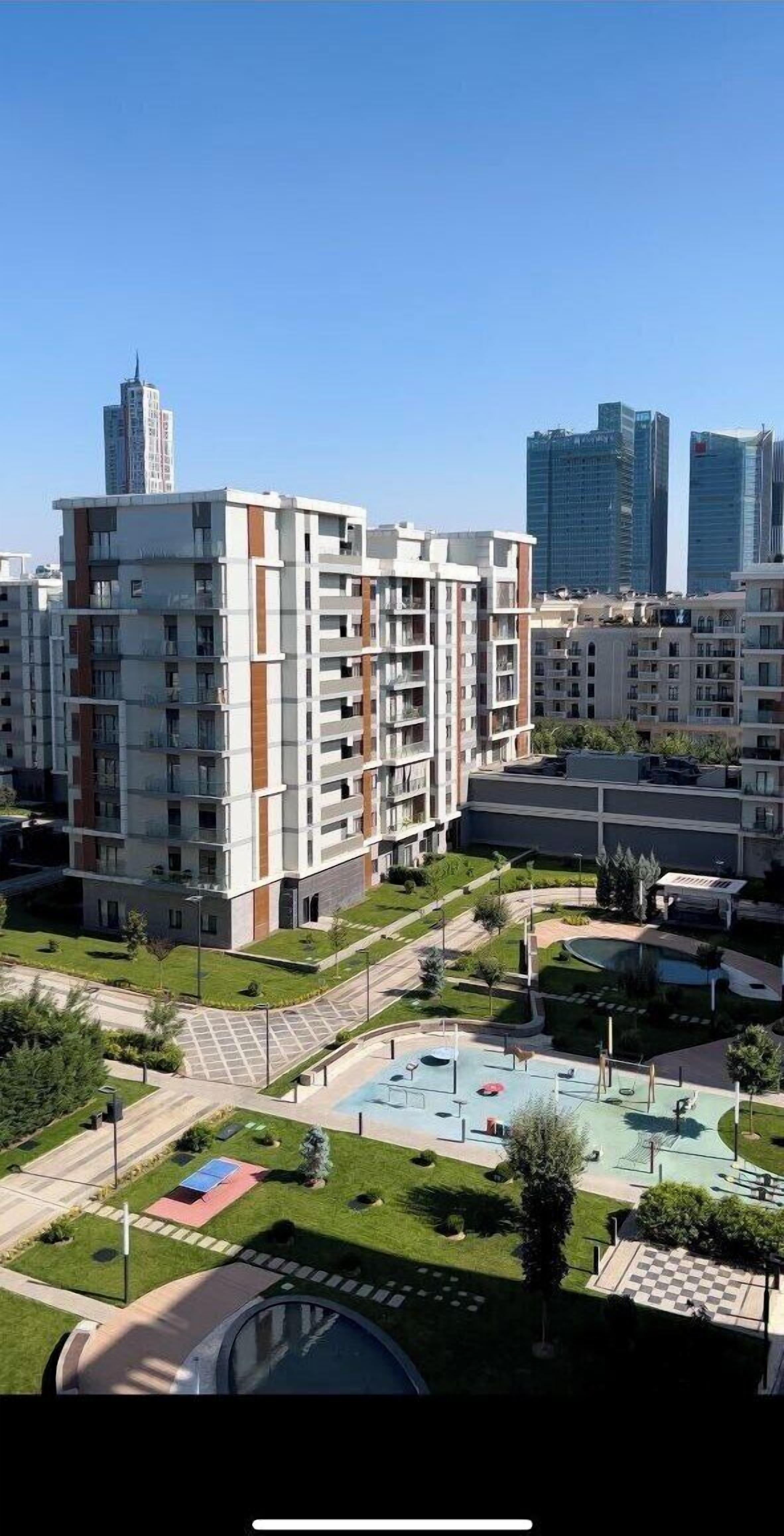 A multi-story residential building with balconies, a swimming pool, and a landscaped courtyard.