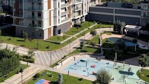 A multi-story residential building with balconies, a swimming pool, and a landscaped courtyard. - Apartments Tashkent city Gardens A1 (Tashkent)