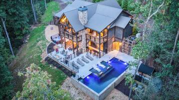 Una amplia cabaña de madera con jacuzzi y zona de estar al aire libre.