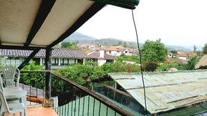 Een balkon met uitzicht op huizen en groen.