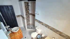 Een kleine badkamer met toilet, wastafel en bad.