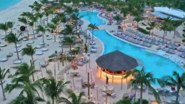 Ein Resort mit großem Pool, Palmen und Strand.