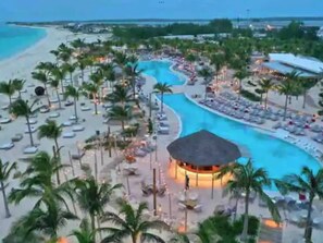 Un complexe hôtelier doté d’une grande piscine, de palmiers et d’une plage.