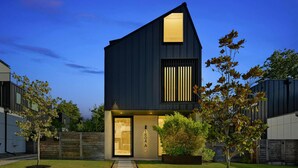 A modern two-story house with a dark exterior, a visible garage door, and a well-maintained lawn with a stone pathway leading to the entrance. - Stunning Modern Zilker Home with Private Pool, Designer Touches & Prime Location (Austin)