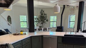 Una cocina moderna con una isla central, armarios oscuros y un lavavajillas de acero inoxidable.