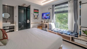A modern bedroom with a bed, bedside table, and a desk with a computer. - Blooming Lotus Hostel (Hangzhou)