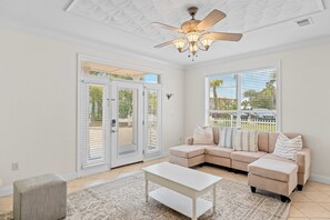A living room with a beige sectional sofa, a white coffee table, and a ceiling fan. - Sleeps 36 2 Homes, Walk to Beach, Priv Pool + Hot Tub Tidal Wave & Seacrest (Destin)