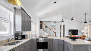 A modern kitchen with grey cabinets, stainless steel appliances, and a large island. - Sleeps 36 2 Homes, Walk to Beach, Priv Pool + Hot Tub Tidal Wave & Seacrest (Destin)