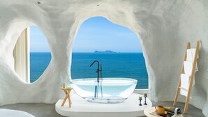 A modern bathroom with a glass bathtub, a wooden ladder, and a view of the sea. - Miyue Santorini Seaview Resort Hotel (Huizhou)