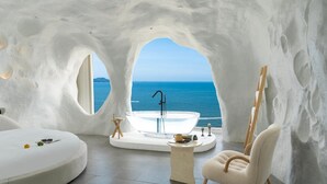 A modern, white-themed bathroom with a bathtub, a round seating area, and a view of the sea. - Miyue Santorini Seaview Resort Hotel (Huizhou)