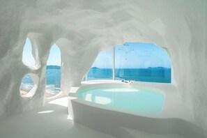 A modern, minimalist bathroom with a large bathtub and a view of the sea. - Miyue Santorini Seaview Resort Hotel (Huizhou)