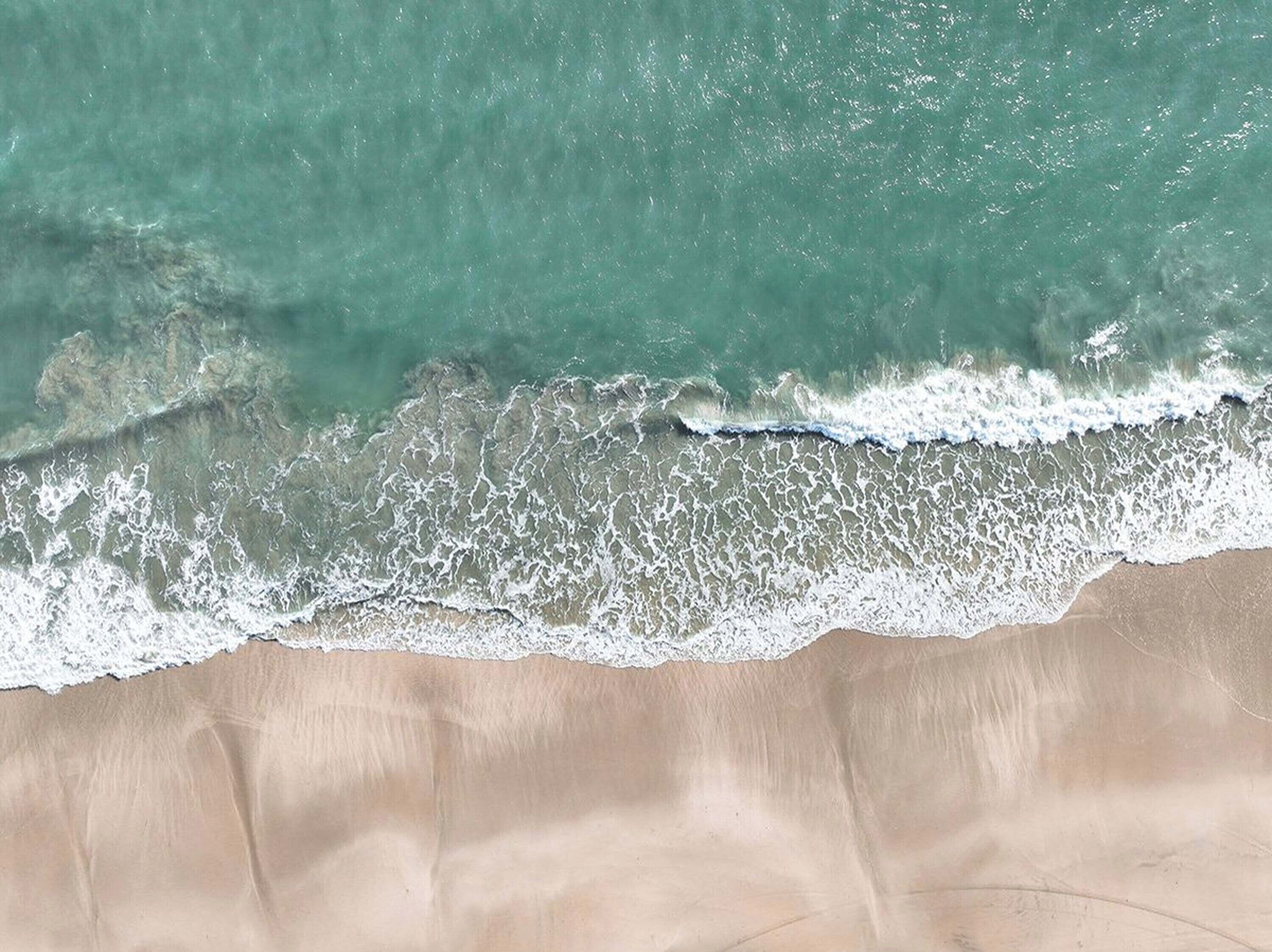 A sandy beach with waves crashing onto the shore.
