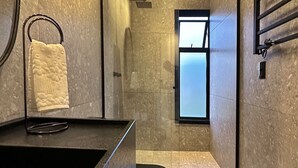 A modern bathroom with a dark countertop, a towel rack, and a large mirror. - Cozy house in the countryside of Garibaldi, close to wineries and restaurants (Garibaldi)