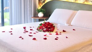 A neatly made bed with white linens and a bouquet of red roses in the center. - Cozy house in the countryside of Garibaldi, close to wineries and restaurants (Garibaldi)