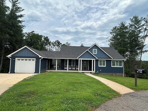 A two-story house with a garage, a covered porch, and a well-maintained lawn. - Non-smoking lake house with private beach, dock and kayaks (Nebo)