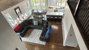 Un loft spacieux avec de hauts plafonds, un coin repas, une cuisine et un salon doté d’un grand canapé d’angle.