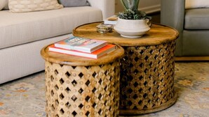 A living room with a sofa, two round wicker side tables, a floor lamp, and a framed picture on the wall. - Cute Bungalow in Central Lubbock (Lubbock)