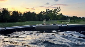 A boat with a glass of beer on the dashboard, surrounded by water and trees.