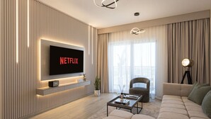 A modern living room with a flat-screen TV displaying 'NETFLIX', a sofa, a coffee table, and a lamp. - 1BDR Premium Yas Island - Ferrari, Sea World, F1 (Abu Dhabi)