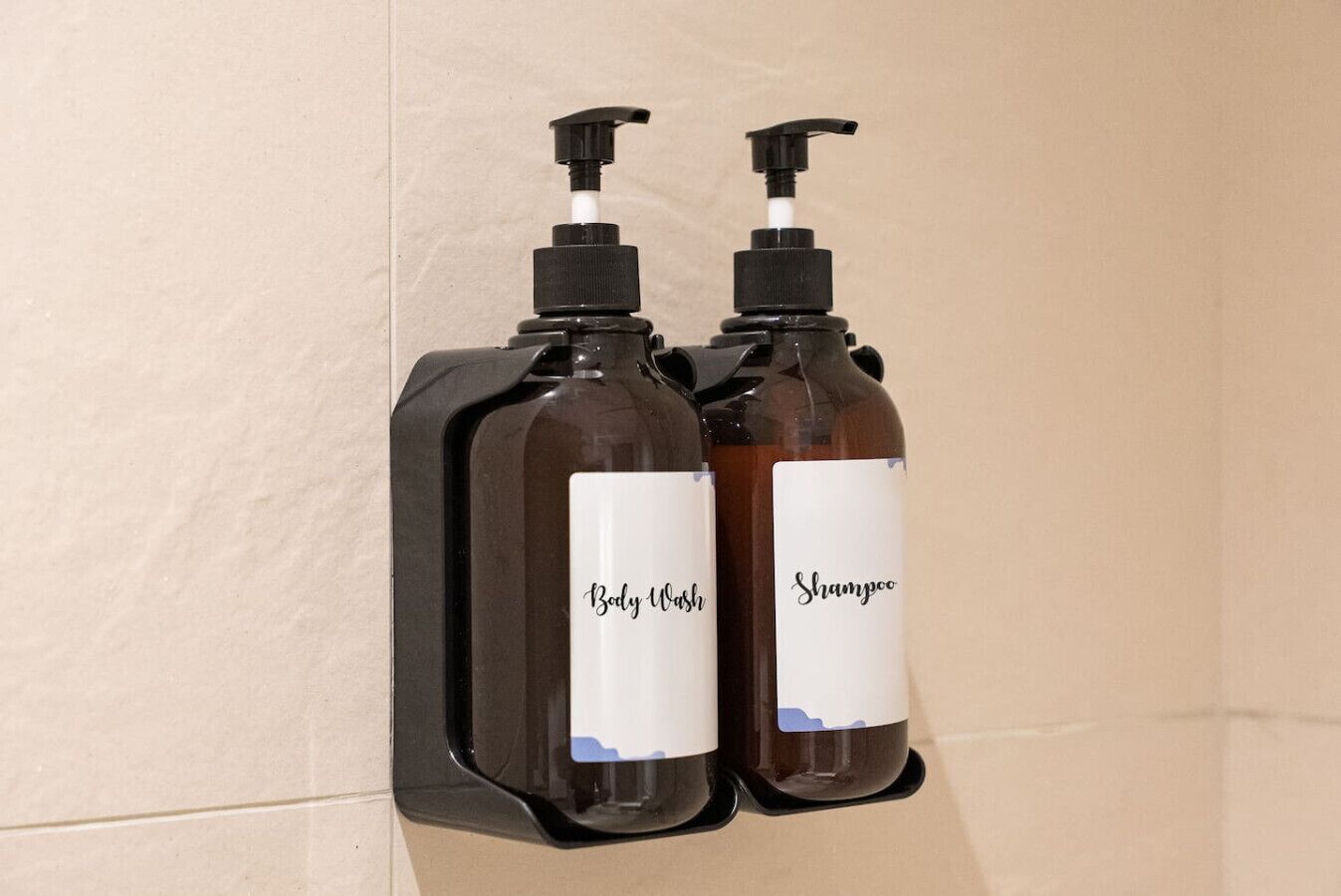Zwei Flaschen Duschgel und Shampoo an der Wand befestigt.