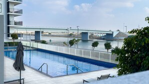 A swimming pool with a view of a bridge and river. - 1BDR Premium Yas Island - Ferrari, Sea World, F1 (Abu Dhabi)