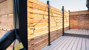 En træterrasse med gelænder og lyskæder.