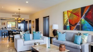 A modern living room with two sofas, a coffee table, and a dining area in the background.