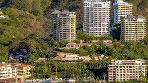 A coastal resort with multiple high-rise buildings, a sandy beach, and lush greenery.