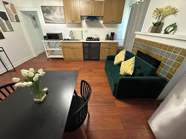 A compact kitchen with wooden cabinets, a microwave, and a coffee maker.