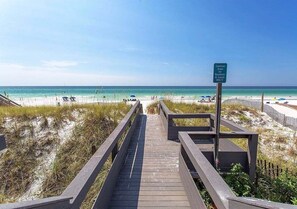 A wooden boardwalk leading to a beach with a sign indicating common areas for residents and guests only. - BEACH THERAPY: Game On! Cornhole, Table Tennis & Poolside Bar with Private Beach! (Miramar Beach)