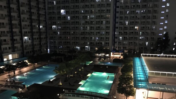 A multi-level hotel with several swimming pools, each surrounded by lounge areas and trees. - Cosy Condo with Balcony at Makati SM Jazz (Makati City)