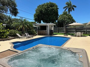 A swimming pool with a hot tub, lounge chairs, and a barbecue area. - Jupiter Heated Pool/Spa Luxury Home with Private Oasis (Jupiter)