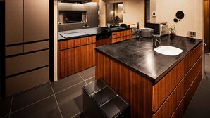 A modern kitchen with a central island, built-in appliances, and a small trash bin. - A private villa where you can step away from your daily life and savor "extra... (karatushi watada honmura)
