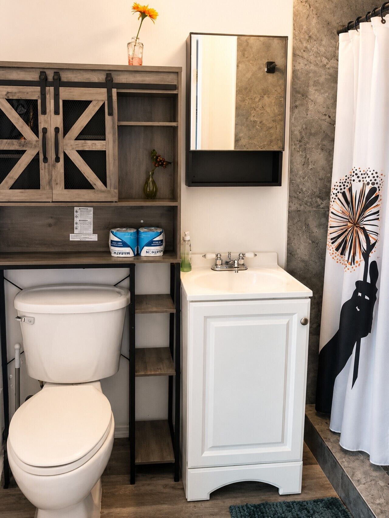 A bathroom with a toilet, a sink, a mirror, and a shower curtain.