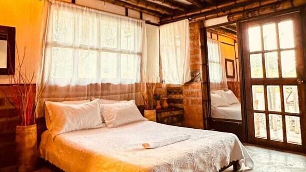 A room with a bed, a window, and a door. - Villa Tikuna (San Sebastian de Mariquita)