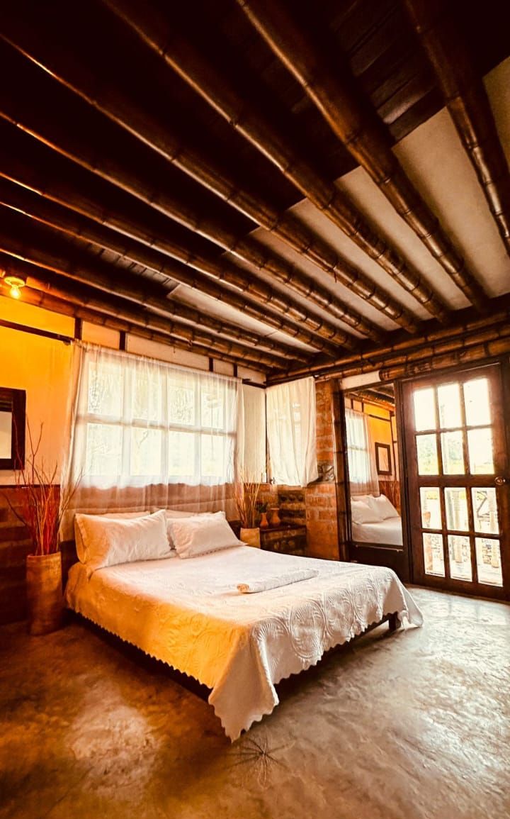 Una habitación con una cama, una ventana y una puerta.
