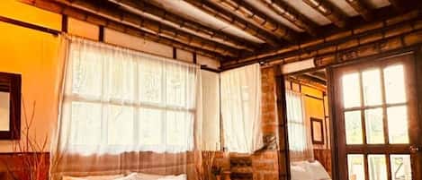 Una habitación con una cama, una ventana y una puerta.